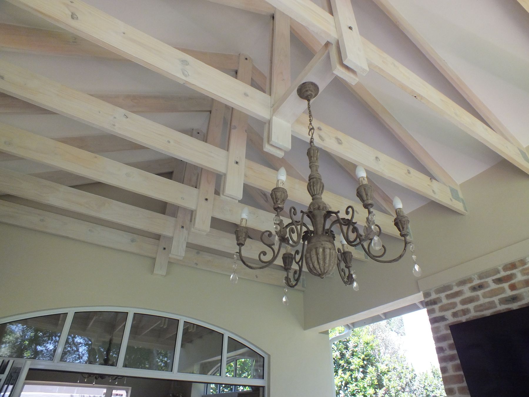 Whitewashed pine truss and chandelier — House in Atholl