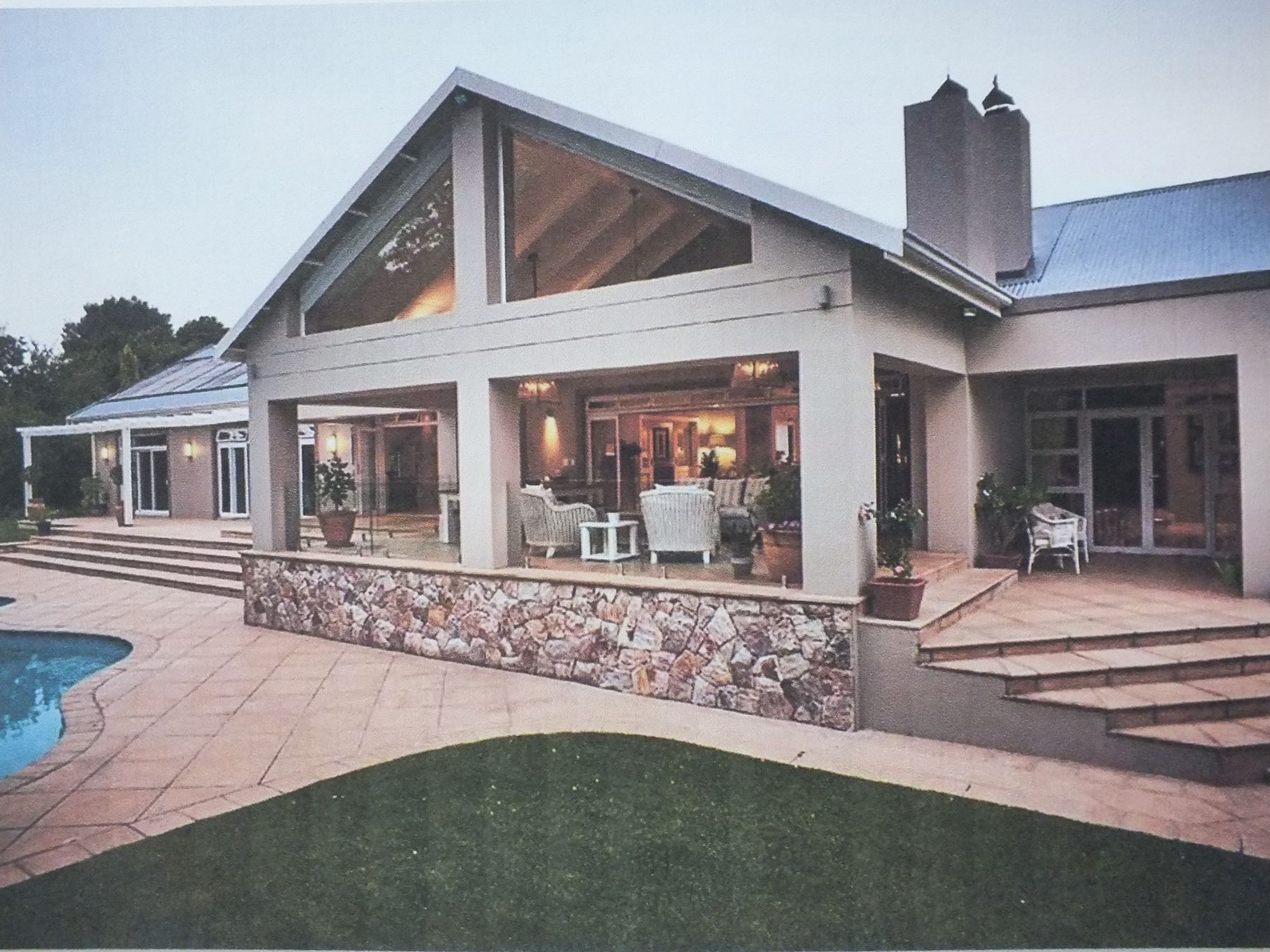 Hurlingham house after the alteration — glazed gable patio on a stone plinth above the pool
