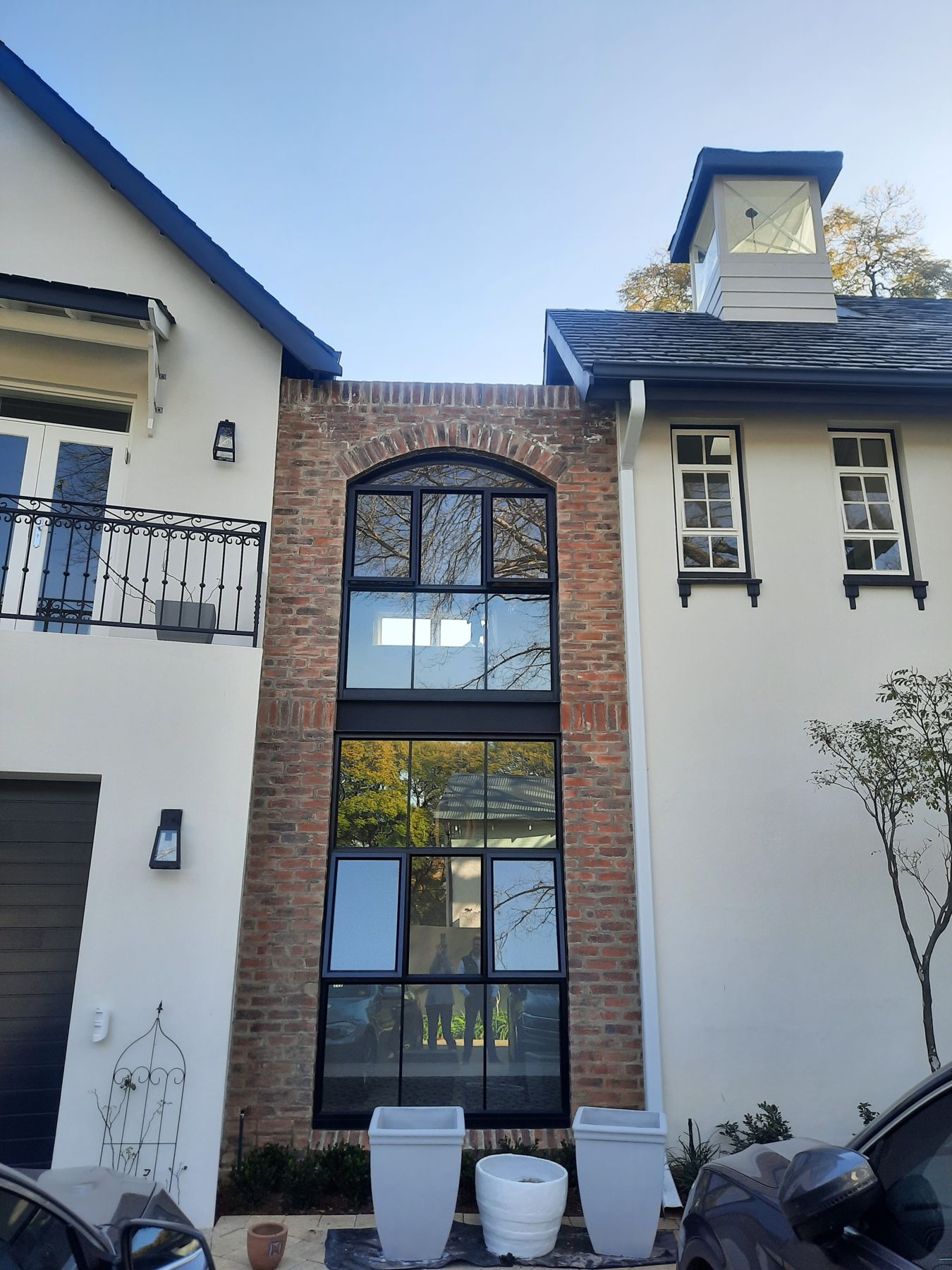 Face-brick stair tower with arched steel window — Heritage house in Melrose