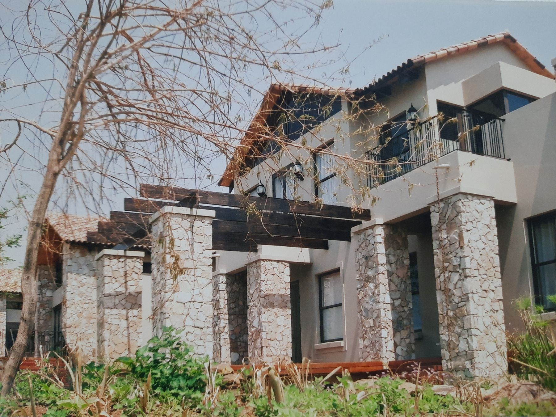 New house at Blair Atholl with dry-stone pillars and a timber pergola