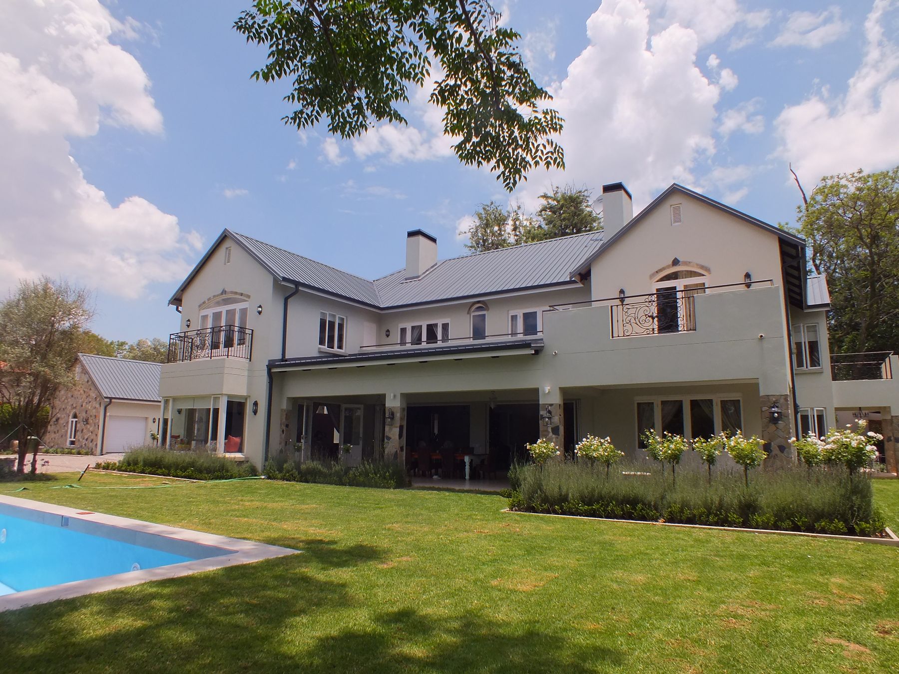 New house in Bryanston by Debby Searle Architect, seen across the pool and lawn